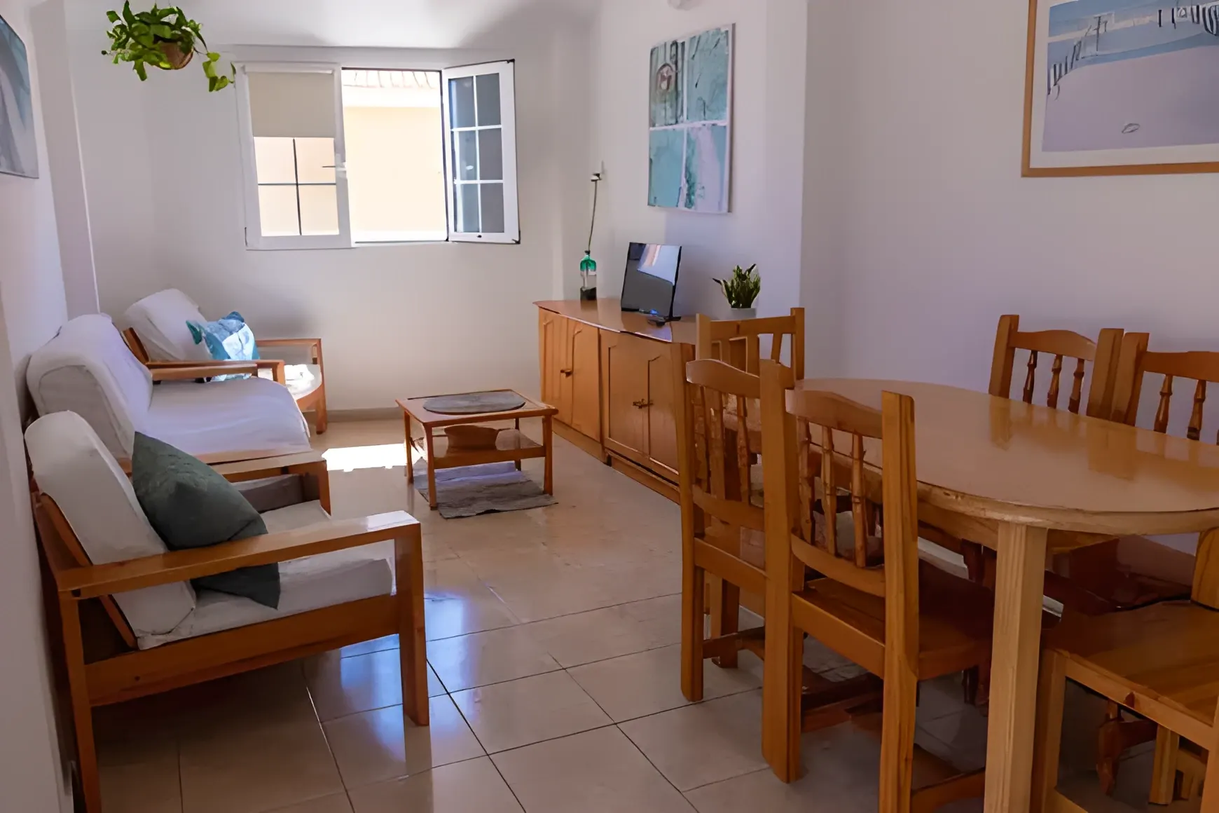Salón-comedor con butacas de madera y mesa para cuatro