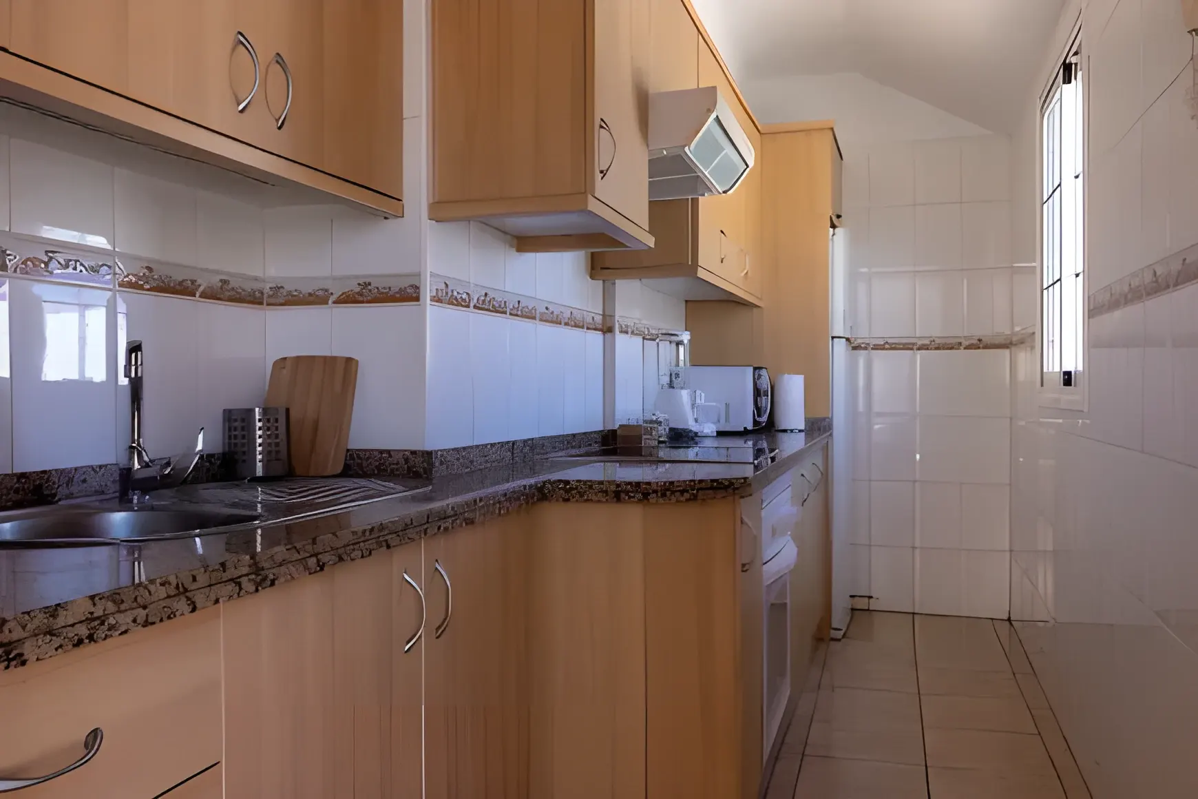 Cocina con muebles de madera, tostadora y hervidor