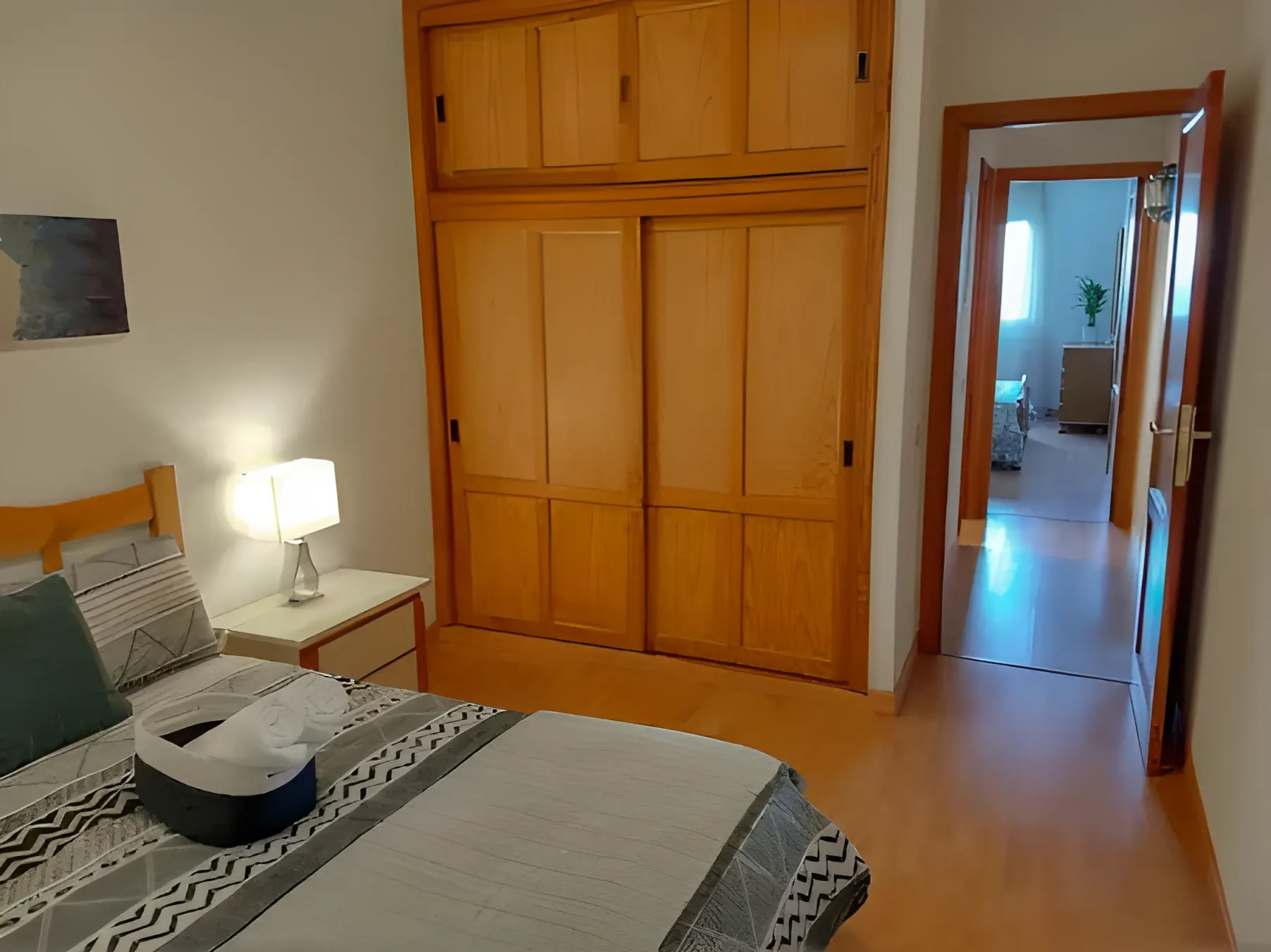 Dormitorio con armario empotrado de madera y salida al pasillo
