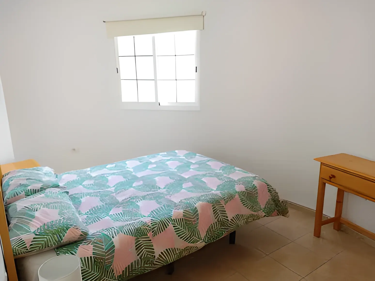 Dormitorio con cama de matrimonio y ventana al patio