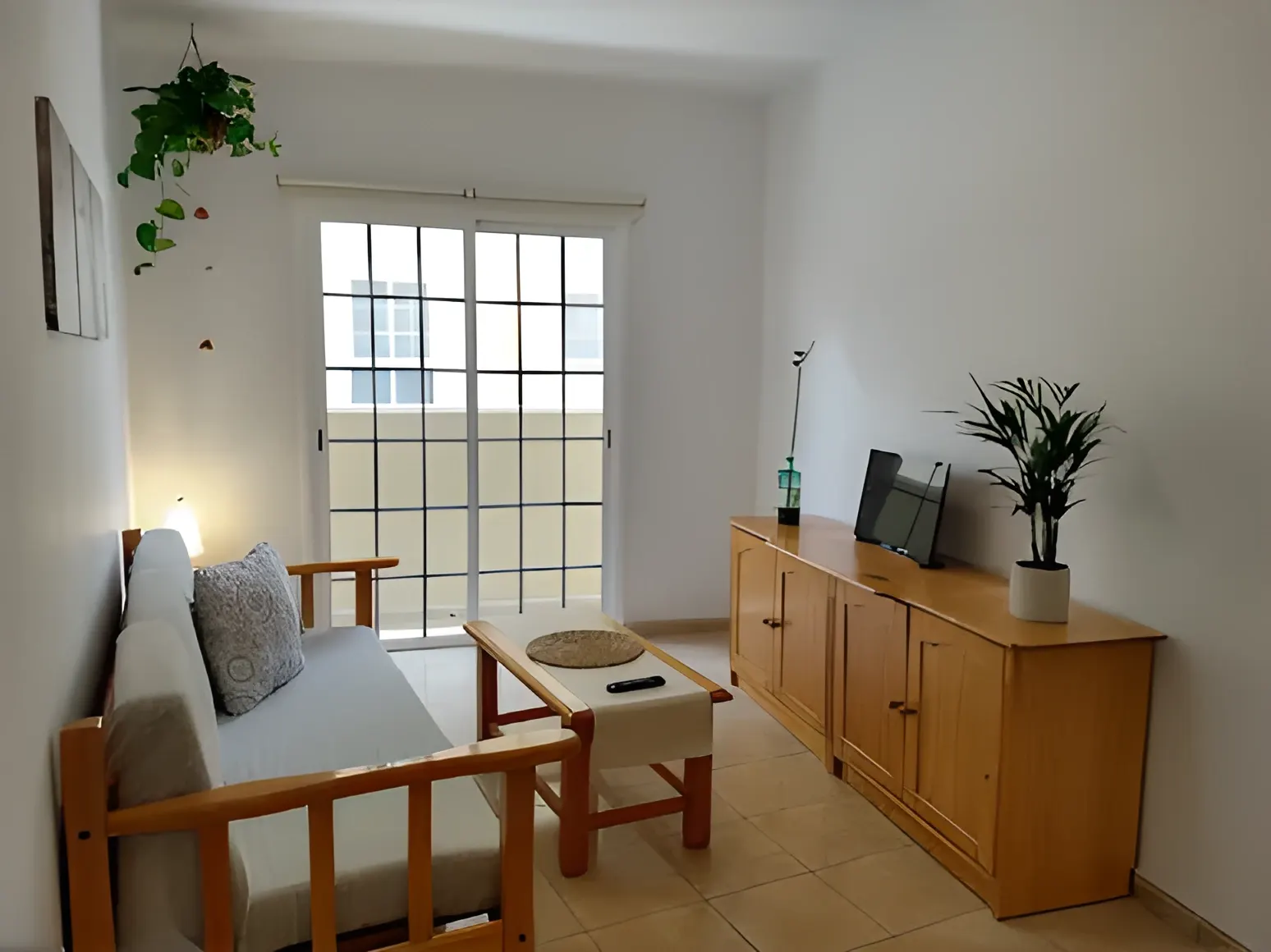 Salón con sofá, aparador y puerta ventana